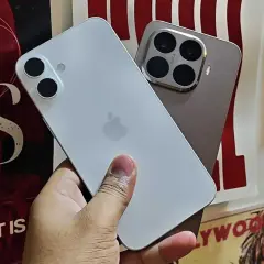 En hand håller en vit iPhone. Bredvid syns en annan telefon med fyra kameror. Kanske dags att byta från Android till iPhone?