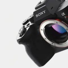 Närbild på en svart Sony Alpha 7R med E-mount. Kamerans grepp och objektivfattning syns tydligt.