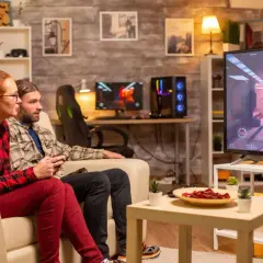Ett par spelar tv-spel på en stor skärm, en bekväm casta från dator till tv-upplevelse.