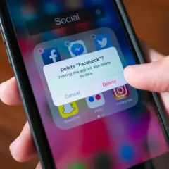 En person trycker på "Delete" för att ta bort appar från sin telefon.