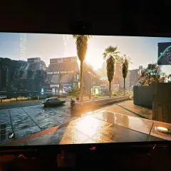En solig stadsgata i Cyberpunk 2077, med palmer och neonljus. HDR vs SDR ger en otrolig detaljrikedom.