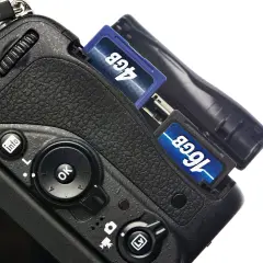 Nära bild på en digitalkamera med två SD-kort insatta, 4GB och 16GB. Förberedelser för att importera bilder från kamera till dator.