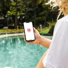 En person håller upp en mobil med Instagram Reels-ikonen. Vad betyder reels? Korta videoklipp som delas på sociala medier.