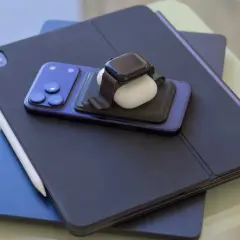 En stapel Apple-produkter: en iPad med tangentbord, en iPhone, en Apple Watch och AirPods. Perfekt för att skapa egna flera bakgrundsbilder iPhone.