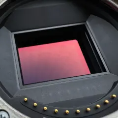 Närbild på en kameras sensor. Den rektangulära sensorn har en rödaktig ton.