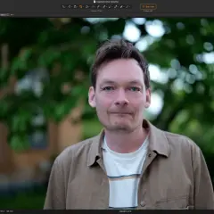 Man med blå ögon redigeras i en bildredigeringsapp gratis. Bakgrunden är suddig grönska.