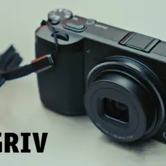 En svart Ricoh GR IV-kamera med en rem.