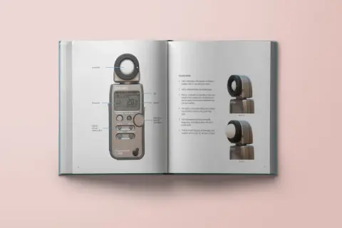 En sida i en bok visar en ljusmätare och instruktioner för dess användning. Bilden visar analoga bilder av ljusmätaren och dess tillbehör.