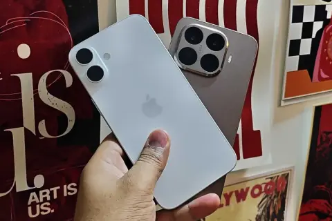 En hand håller en vit iPhone. Bredvid syns en annan telefon med fyra kameror. Kanske dags att byta från Android till iPhone?