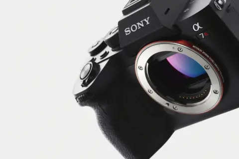 Närbild på en svart Sony Alpha 7R med E-mount. Kamerans grepp och objektivfattning syns tydligt.
