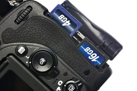 Nära bild på en digitalkamera med två SD-kort insatta, 4GB och 16GB. Förberedelser för att importera bilder från kamera till dator.