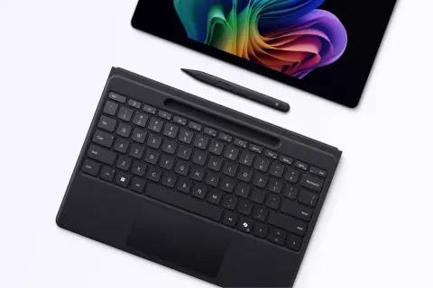 Svart tangentbord och penna för en Surface Pro med en färgglad bakgrund på skärmen.
