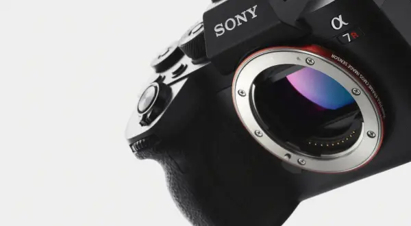 Närbild på en svart Sony Alpha 7R med E-mount. Kamerans grepp och objektivfattning syns tydligt.