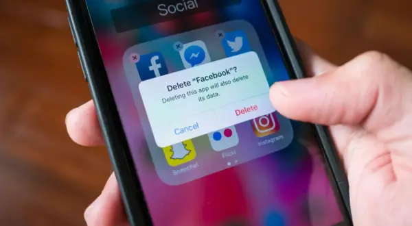 En person trycker på "Delete" för att ta bort appar från sin telefon.