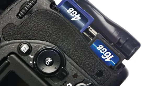 Nära bild på en digitalkamera med två SD-kort insatta, 4GB och 16GB. Förberedelser för att importera bilder från kamera till dator.