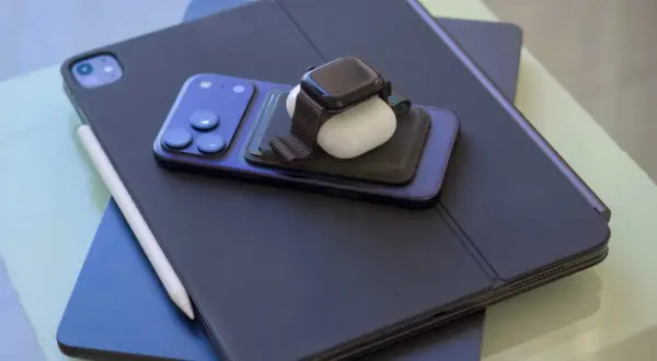 En stapel Apple-produkter: en iPad med tangentbord, en iPhone, en Apple Watch och AirPods. Perfekt för att skapa egna flera bakgrundsbilder iPhone.