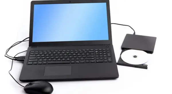 Svart laptop med en extern dvd-enhet och en skiva bredvid. En mus är ansluten till datorn.