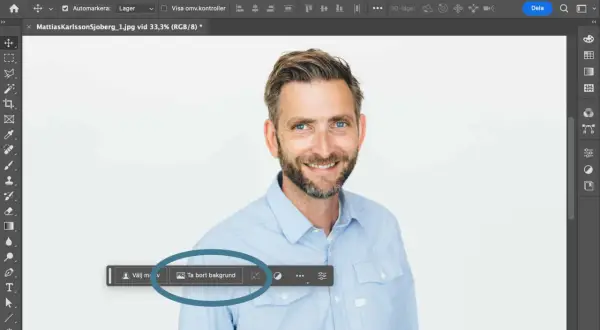 Man använder Photoshop för att ta bort bakgrunden på en bild av en leende man.