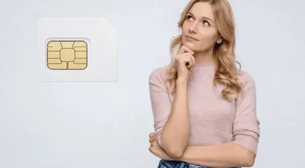 Kvinna funderar på att flytta simkort till ny mobil.