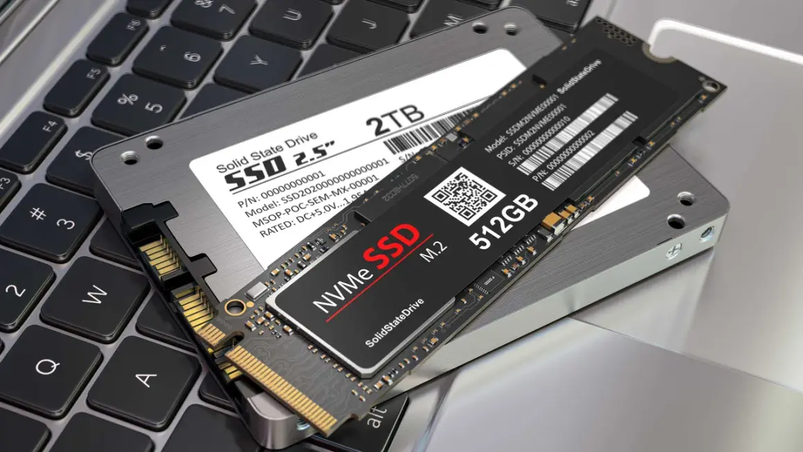 Två SSD-enheter, en 2,5-tums och en M.2 NVMe, ligger på ett laptop-tangentbord. Perfekt för att installera SSD och uppgradera din dator.