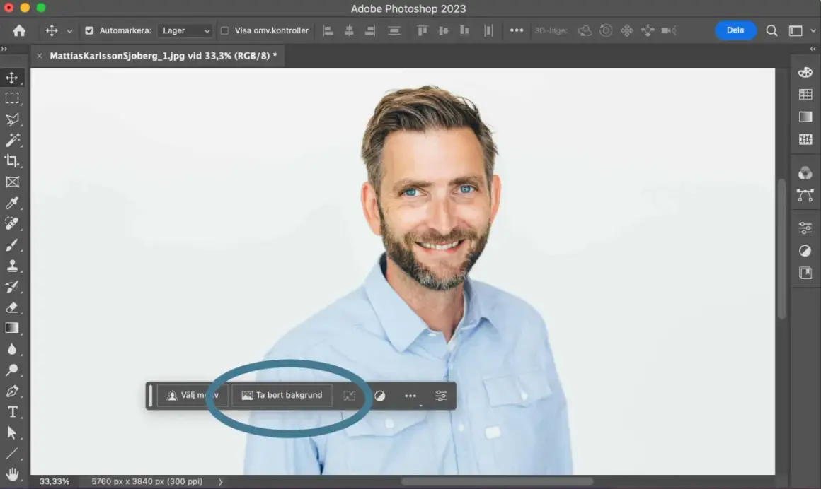 Man använder Photoshop för att ta bort bakgrunden på en bild av en leende man.