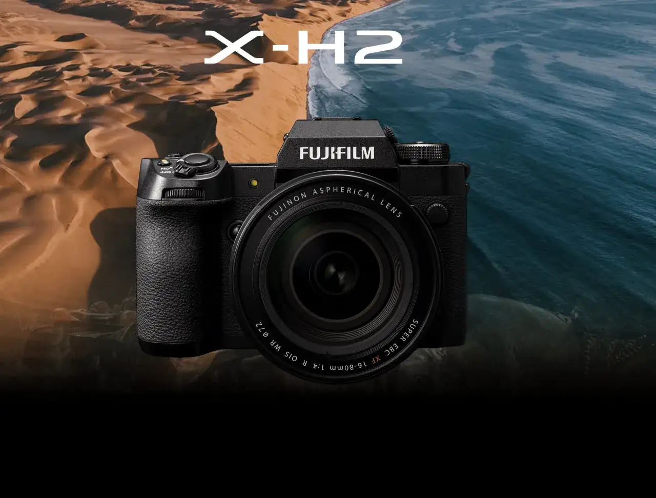 Fujifilm X-H2-kameran framsida med en lins, placerad framf&ouml;r en bakgrund av sanddyner och hav.