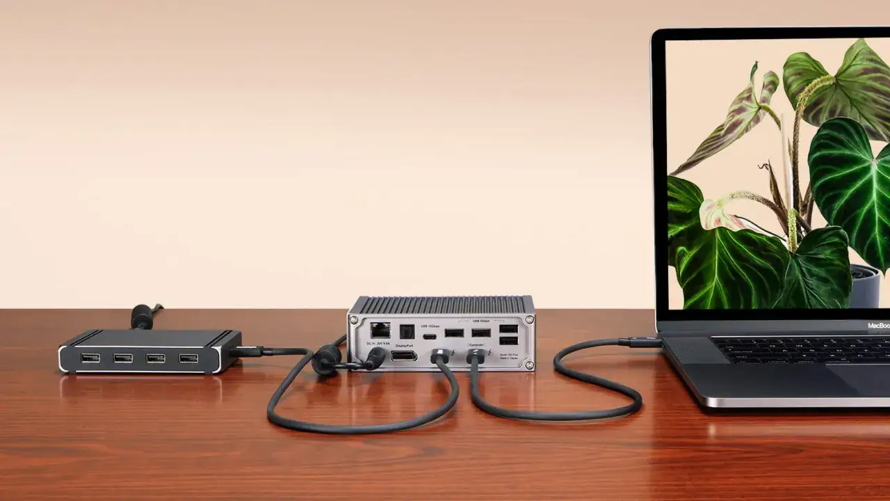 En dockningsstation med thunderbolt 4-portar ansluten till en laptop. En annan hub med USB-portar syns till vänster.