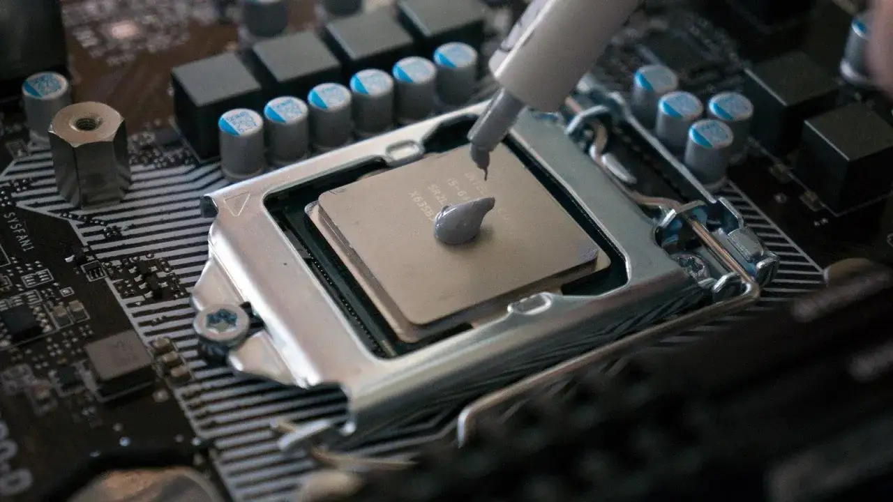 En spruta applicerar kylpasta p&aring; en dators processor. Denna kylpasta, &auml;ven k&auml;nd som 