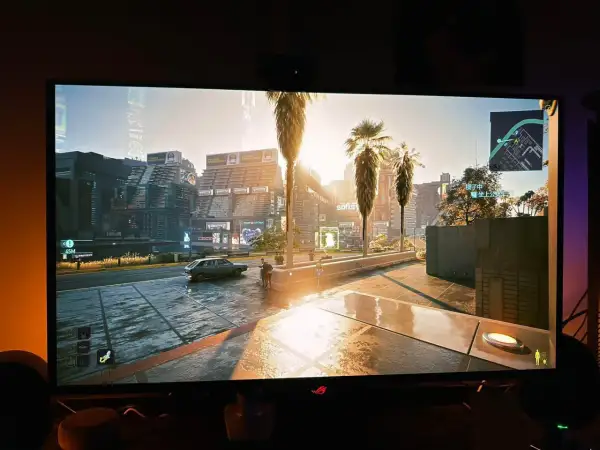 En solig stadsgata i Cyberpunk 2077, med palmer och neonljus. HDR vs SDR ger en otrolig detaljrikedom.